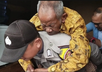 Walaupun Hujan Lebat, Bhabinkamtibmas Polres Tanjungpinang Bopong Warganya Yang Sakit Untuk Berobat